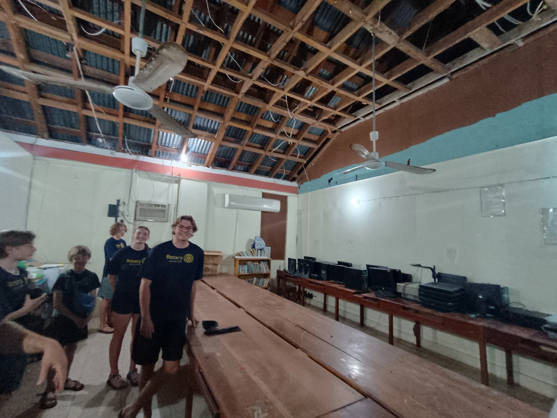 People inside the school computer lab beneath the exposed roof